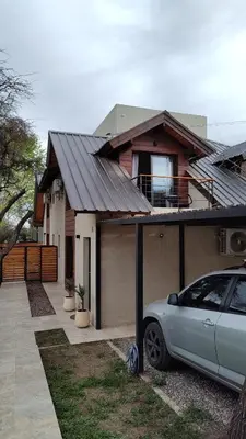 a house with a car parked in front of it at Duplex Zekkei in Villa General Belgrano