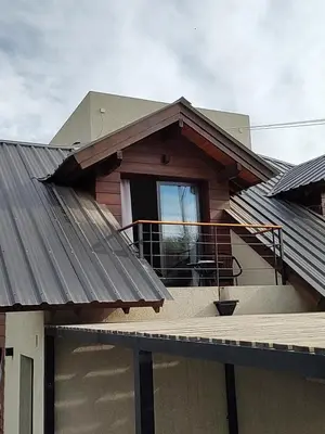 a house with a porch and a balcony at Duplex Zekkei in Villa General Belgrano