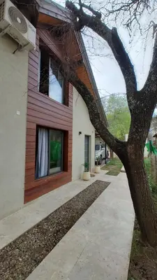 a house with a tree in front of it at Duplex Zekkei in Villa General Belgrano