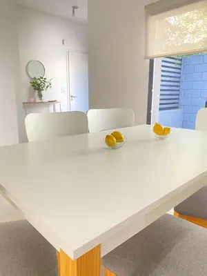a white table with two bowls of oranges on it at La Palmerita 9 in Villa Carlos Paz