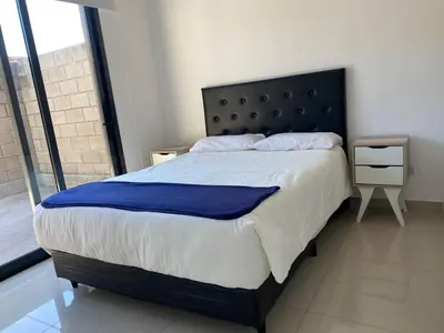 a bedroom with a large bed with a blue blanket at La Palmerita 9 in Villa Carlos Paz