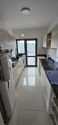 a large kitchen with white appliances and a large window at La Palmerita 9 in Villa Carlos Paz