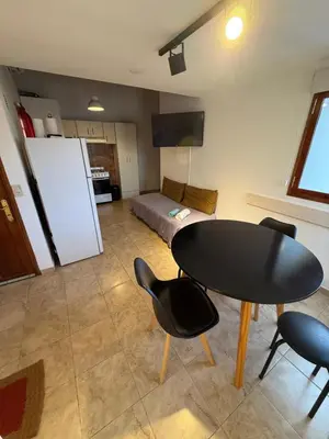 a room with a table and chairs and a bed at Departamento cerca del centro - Carhue in Villa Carlos Paz