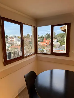 a room with a table and three windows at Departamento cerca del centro - Carhue in Villa Carlos Paz