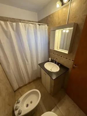 a bathroom with a sink and a toilet and a mirror at Departamento cerca del centro - Carhue in Villa Carlos Paz