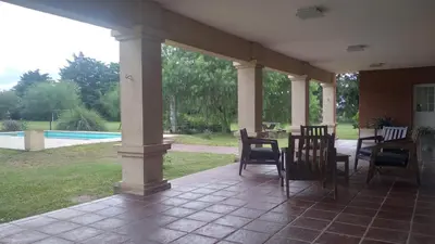 a porch with chairs and a table and a pool at QUINTA LA ESTELA in Pilar