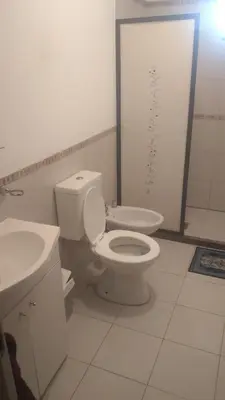 a bathroom with a white toilet and a sink at QUINTA LA ESTELA in Pilar