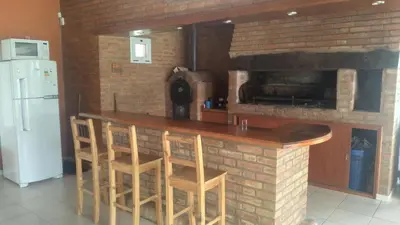a kitchen with a bar with a brick fireplace at QUINTA LA ESTELA in Pilar