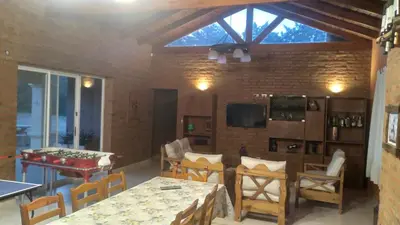 a living room with tables and chairs and a tv at QUINTA LA ESTELA in Pilar