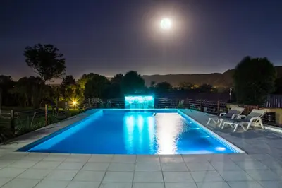a swimming pool at night with the moon overhead at Complejo el Paine in Villa General Belgrano