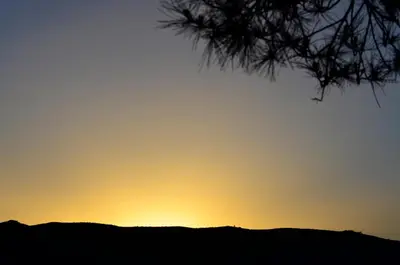 a sunset over a hill with a tree at Complejo el Paine in Villa General Belgrano