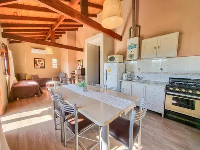 a kitchen with a table and chairs in a room at Complejo el Paine in Villa General Belgrano