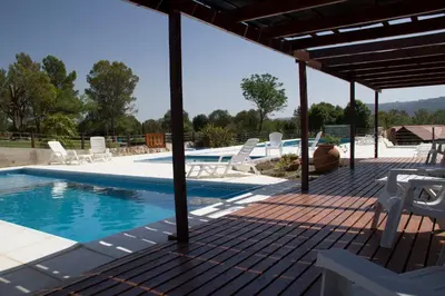 a patio with chairs and a swimming pool at Complejo el Paine in Villa General Belgrano