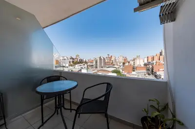a balcony with a table and two chairs and a window at La Rioja 1092 B Alberdi in Cordoba