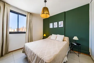 a bedroom with a bed and a green wall at La Rioja 1092 B Alberdi in Cordoba