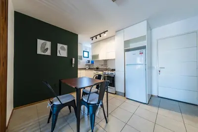 a kitchen with a table and two chairs and a refrigerator at La Rioja 1092 B Alberdi in Cordoba