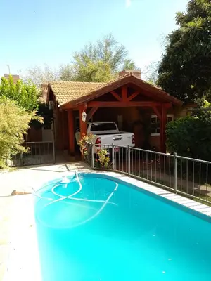 a swimming pool in front of a house at Cabañas Altos del Centro in Merlo