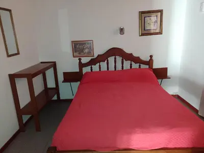 a bedroom with a red bed with a red blanket at Cabañas Altos del Centro in Merlo