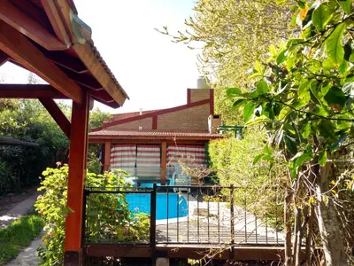 a house with a swimming pool in the yard at Cabañas Altos del Centro in Merlo