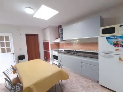 a kitchen with a yellow table and a white refrigerator at Cabañas Altos del Centro in Merlo