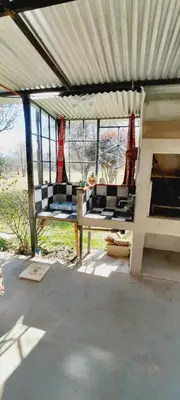 a porch with two chairs in a building with windows at Habitación Suite Sami Llankay in Villa Ciudad Parque