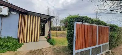 a house with a wooden gate in front of it at Habitación Suite Sami Llankay in Villa Ciudad Parque