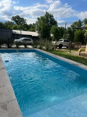 a swimming pool with blue water in a yard at Habitación Suite Sami Llankay in Villa Ciudad Parque