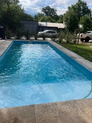 a swimming pool with blue water in a yard at Habitación Suite Sami Llankay in Villa Ciudad Parque