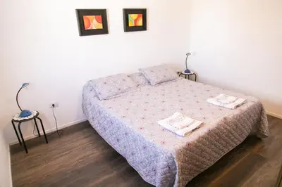 a bedroom with a bed and two night stands at Bello Dpto, 20 minutos al Estadio Kempes, cerca de Quality, Hospital Privado in Cordoba