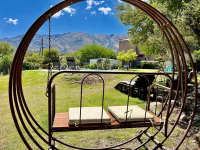 a swing in a yard with mountains in the background at Suite para dos con entrada independiente in Merlo