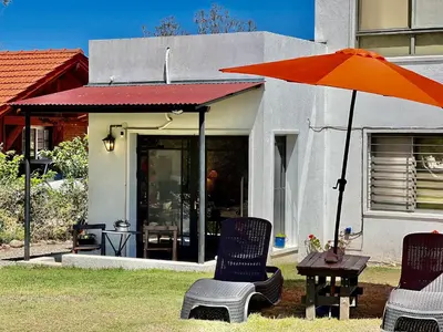 a patio with two chairs and an orange umbrella at Suite para dos con entrada independiente in Merlo