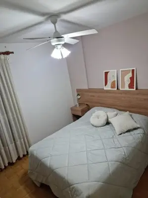 a bedroom with a white bed with a ceiling fan at Departamento 2 ambientes. 2 cuadras de Patio Olmos in Cordoba
