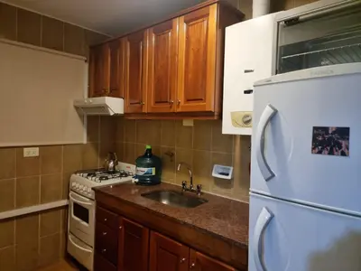 a kitchen with a sink and a refrigerator at Departamento 2 ambientes. 2 cuadras de Patio Olmos in Cordoba