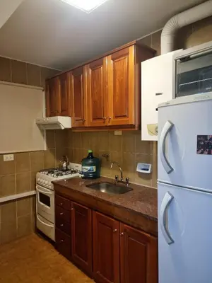 a kitchen with a white refrigerator and a sink at Departamento 2 ambientes. 2 cuadras de Patio Olmos in Cordoba