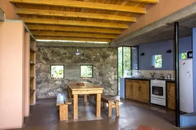 a kitchen with a wooden table and a stone wall at Las Rukas in San Javier