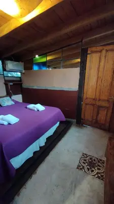 a bedroom with a purple bed and a wooden door at Las Rukas in San Javier