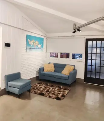 a living room with a blue couch and a chair at CASA TRANSFORMER in Cordoba