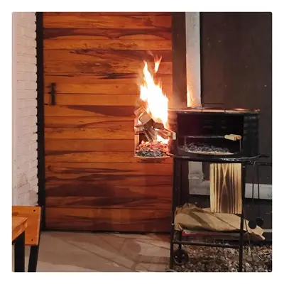 a fire in an oven in a room with a wooden wall at CASA TRANSFORMER in Cordoba