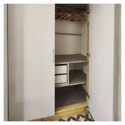 a closet with white walls and a door with shelves at CASA TRANSFORMER in Cordoba
