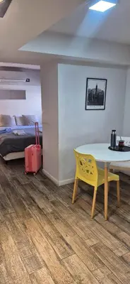 a room with a table and a bed and a yellow chair at Departamento NYC 2 - Edificio VILAUT by INMOVE Temporarios in Cordoba