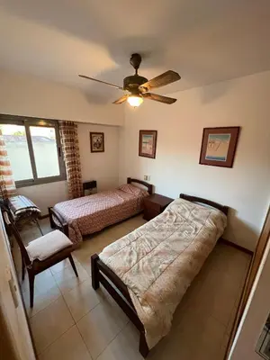 a bedroom with two beds and a ceiling fan at ALQUILO DEPTO AMUEBLADO 2 DORMITORIOS EN MICROCENTRO in Río Cuarto