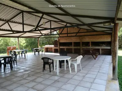 a covered patio with tables and chairs and a grill at Yerba Buena casas de campo - Arroyo de los Patos in Nono