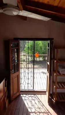 an open door to a patio with a deck at POSADA LAS MARGARITAS in Santa Rosa de Calamuchita