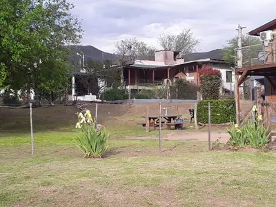 a yard with a picnic table and a house at POSADA LAS MARGARITAS in Santa Rosa de Calamuchita
