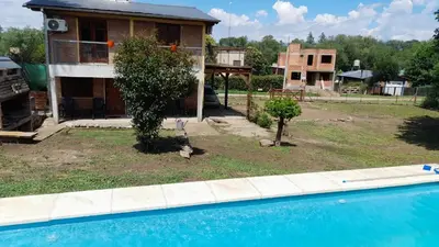 a house with a yard with a swimming pool at POSADA LAS MARGARITAS in Santa Rosa de Calamuchita