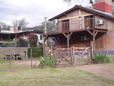 a house with a balcony on the side of it at POSADA LAS MARGARITAS in Santa Rosa de Calamuchita