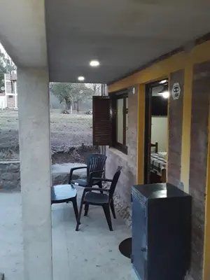 a patio with two chairs and a tv on a porch at POSADA LAS MARGARITAS in Santa Rosa de Calamuchita