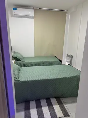 two beds in a room with a mirror at Paseo Quattro Villa Carlos Paz in Villa Carlos Paz