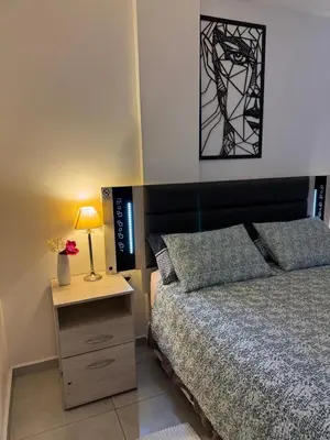 a bedroom with a bed and a table with a lamp at Paseo Quattro Villa Carlos Paz in Villa Carlos Paz