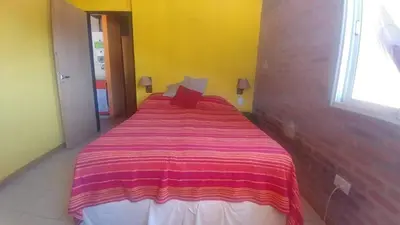 a bedroom with a large bed with a striped blanket at Cabañas Colibri in Las Rabonas